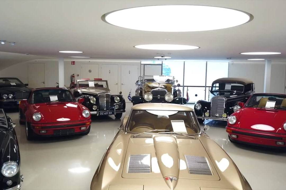 Classic cars parked in rows across a showroom floor.